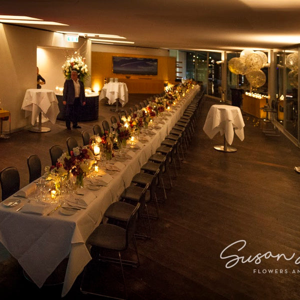The single long birthday table at Catalina Rose Bay, with flowers and candlelight along its length