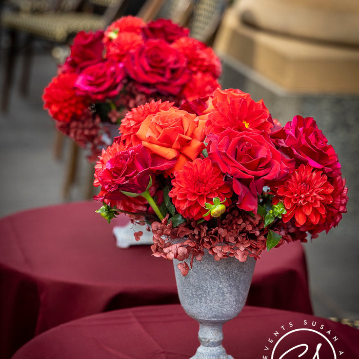 Red roses, coral flowers and burgundy hydrangea in a grey urn