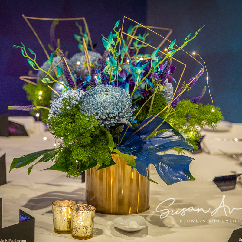 Blue-toned flowers, lime-green foliage, gold geometric details and tiny lights