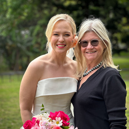 A bride holding a pink and white bouquet beside Susan Avery